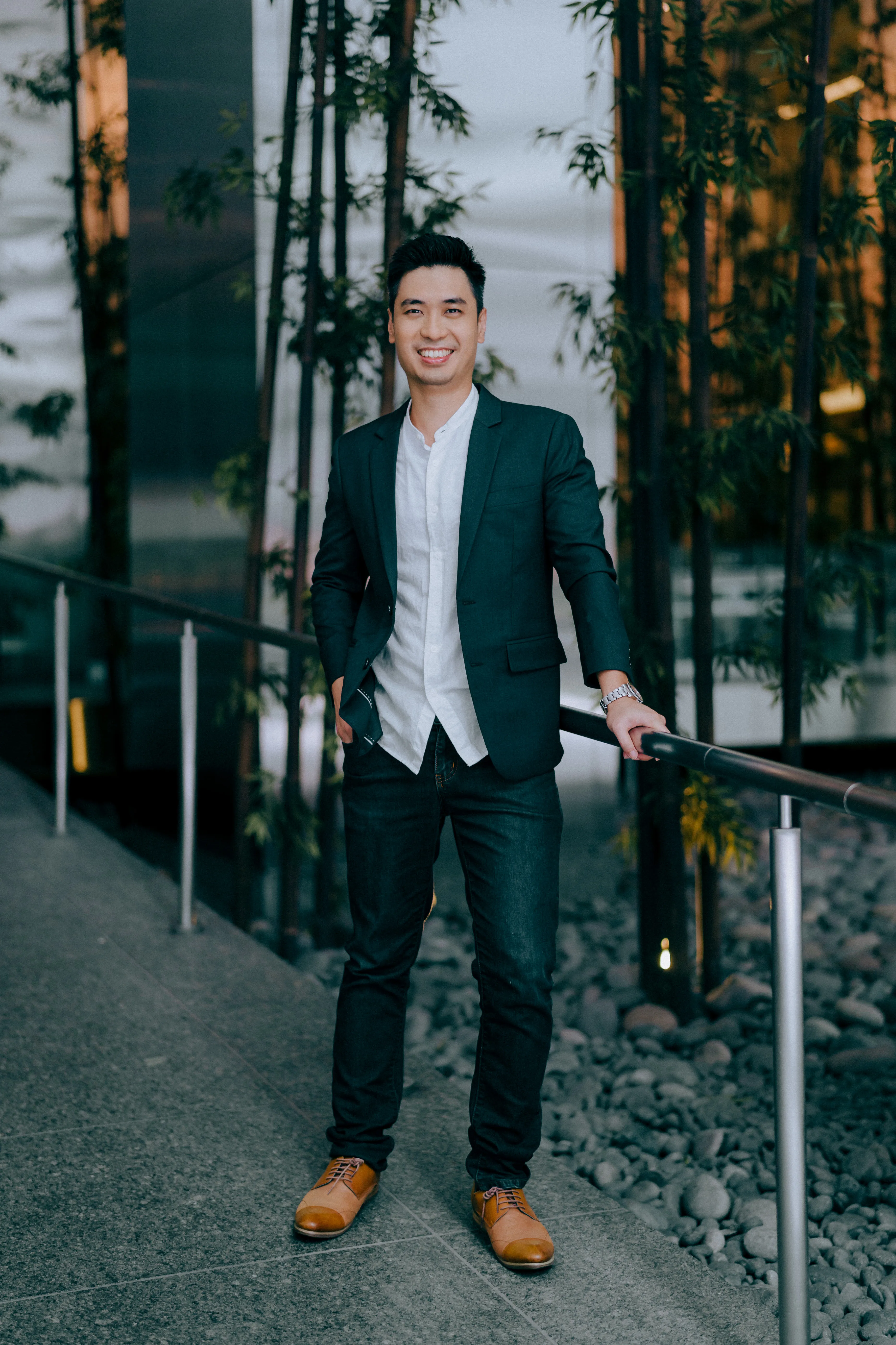 Ling Chun Wei seated in the finexis Advisory office, with an 'Impacting Lives Beyond Finance' wall behind him